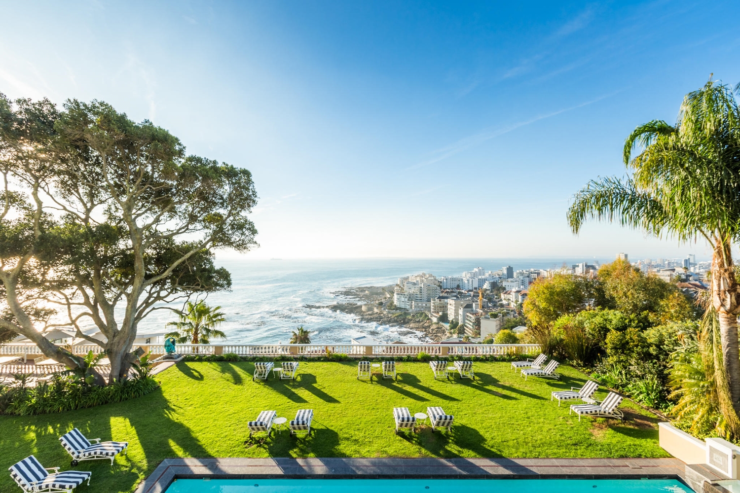 Ellerman-House-Suite-Balcony A manicured lawn with striped loungers and sweeping ocean views at one of the luxury hotels in Cape Town