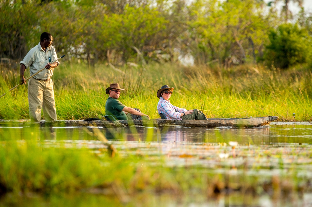 okavango_delta_activities_oddballs_camp Two travellers glide in a mokoro canoe through calm, reed-fringed waters, experiencing the tranquillity of Africa in September.
